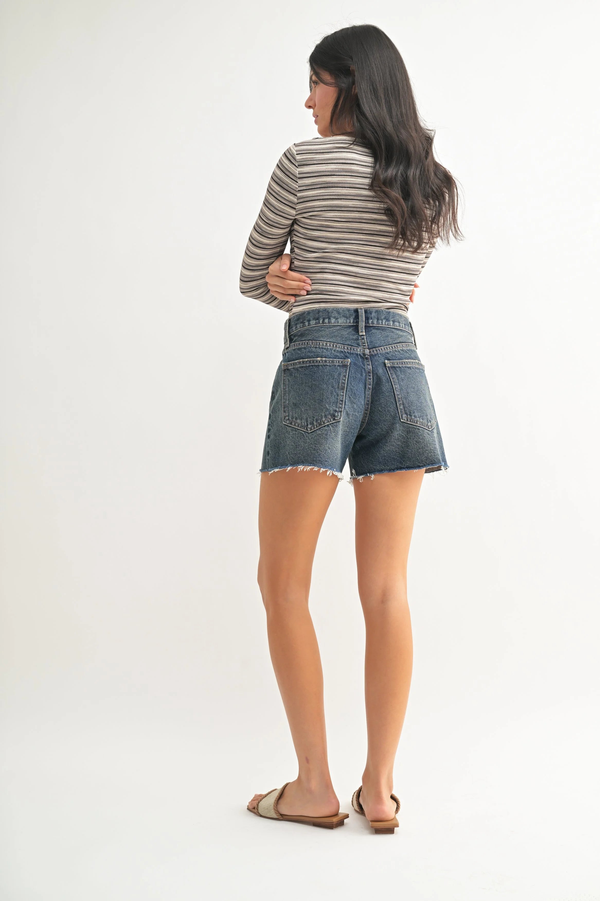 Woman modeling denim on a white background.