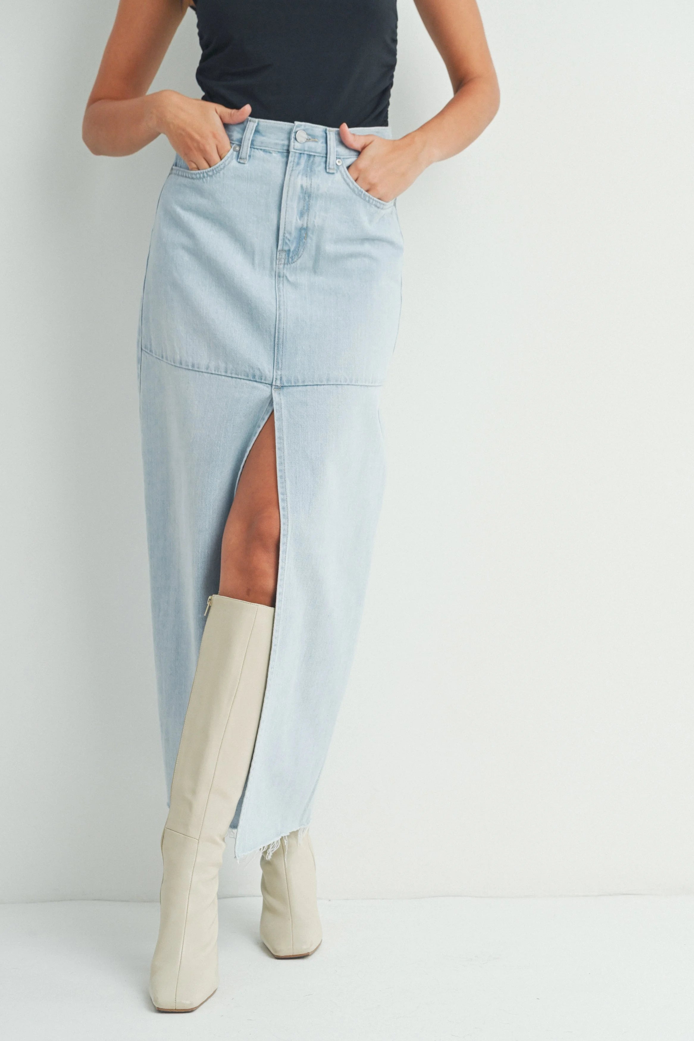 Light blue denim skirt with a front slit worn by a person on a white background