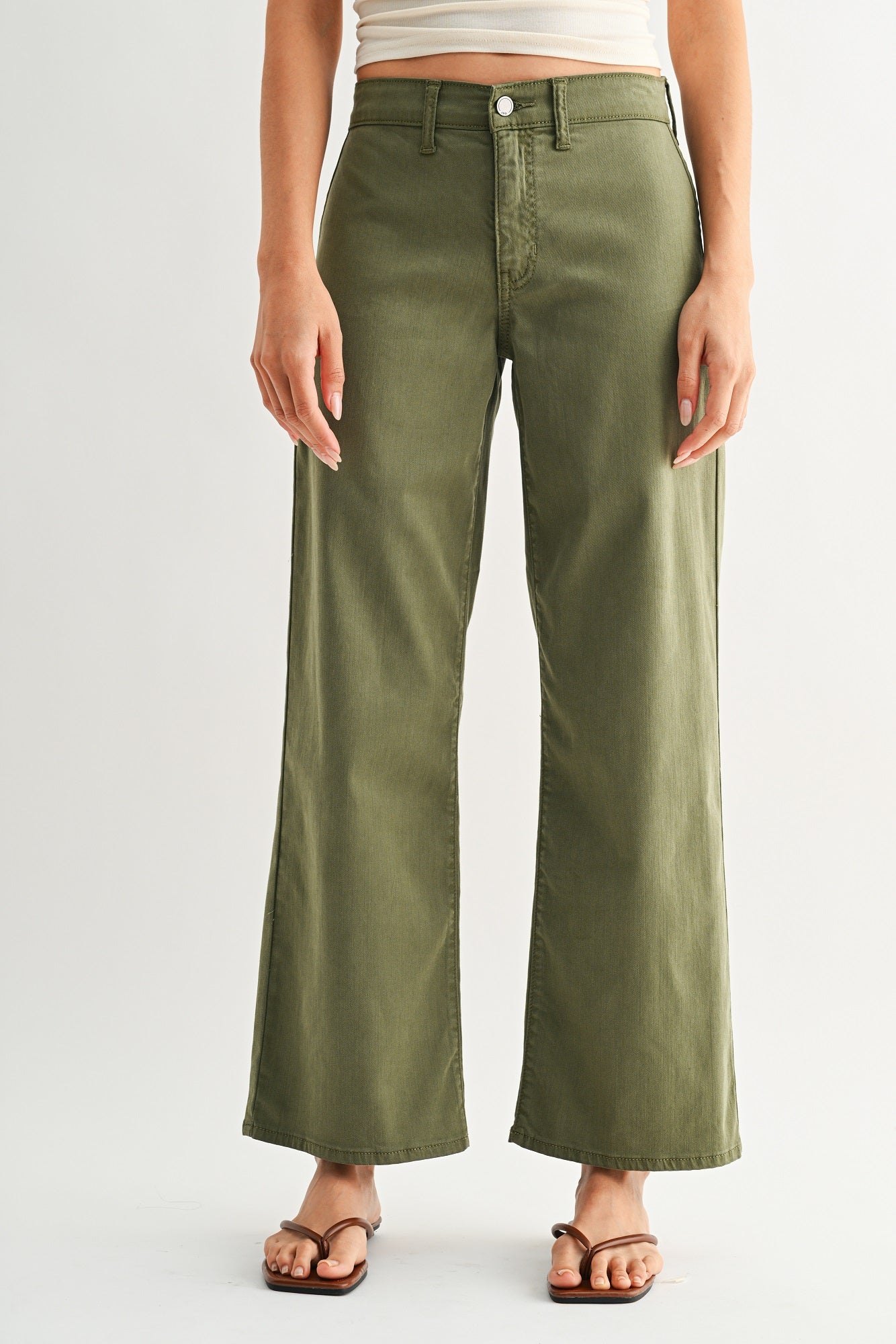 Person wearing olive green pants on a white background