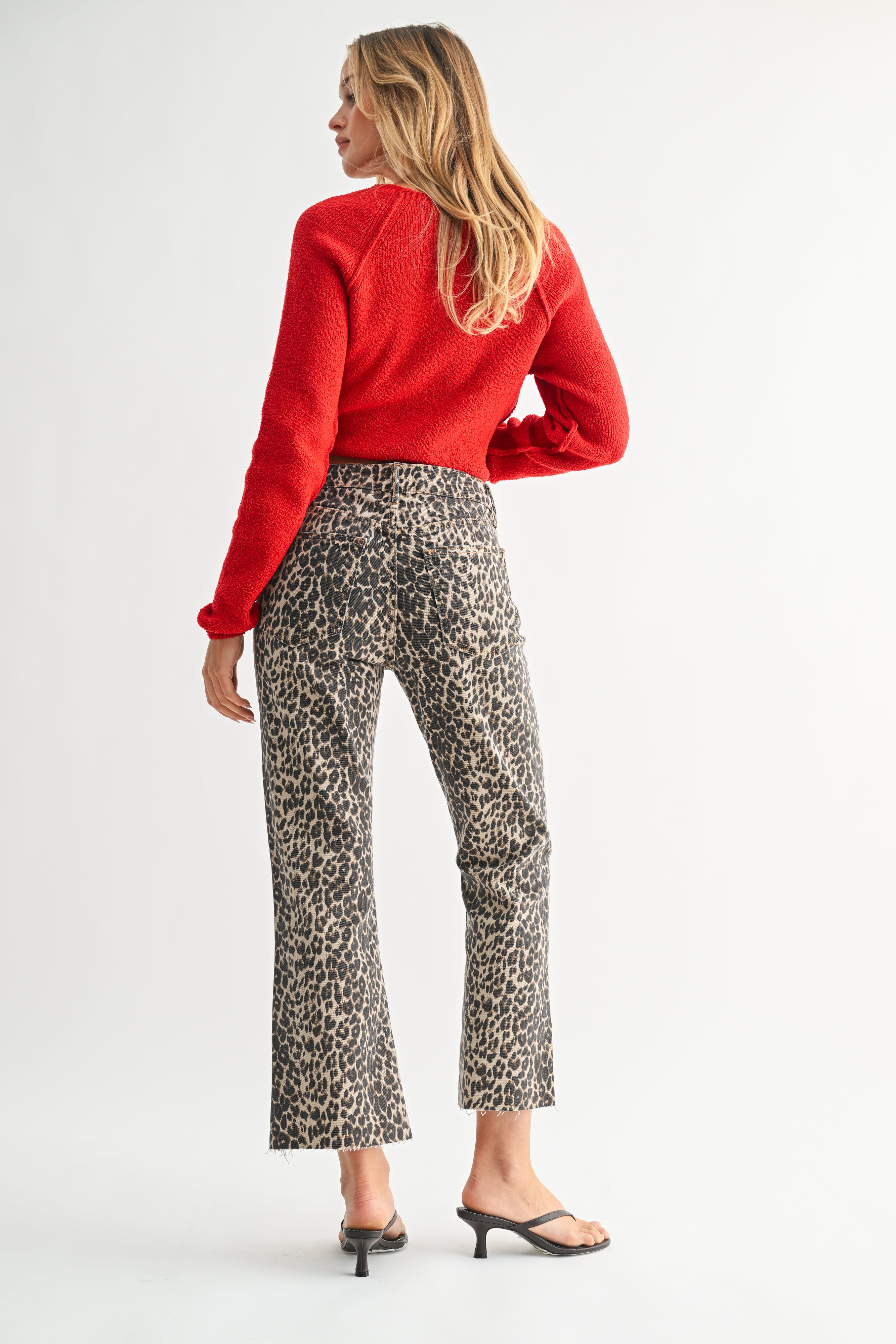 Woman wearing a red top and patterned pants on a white background