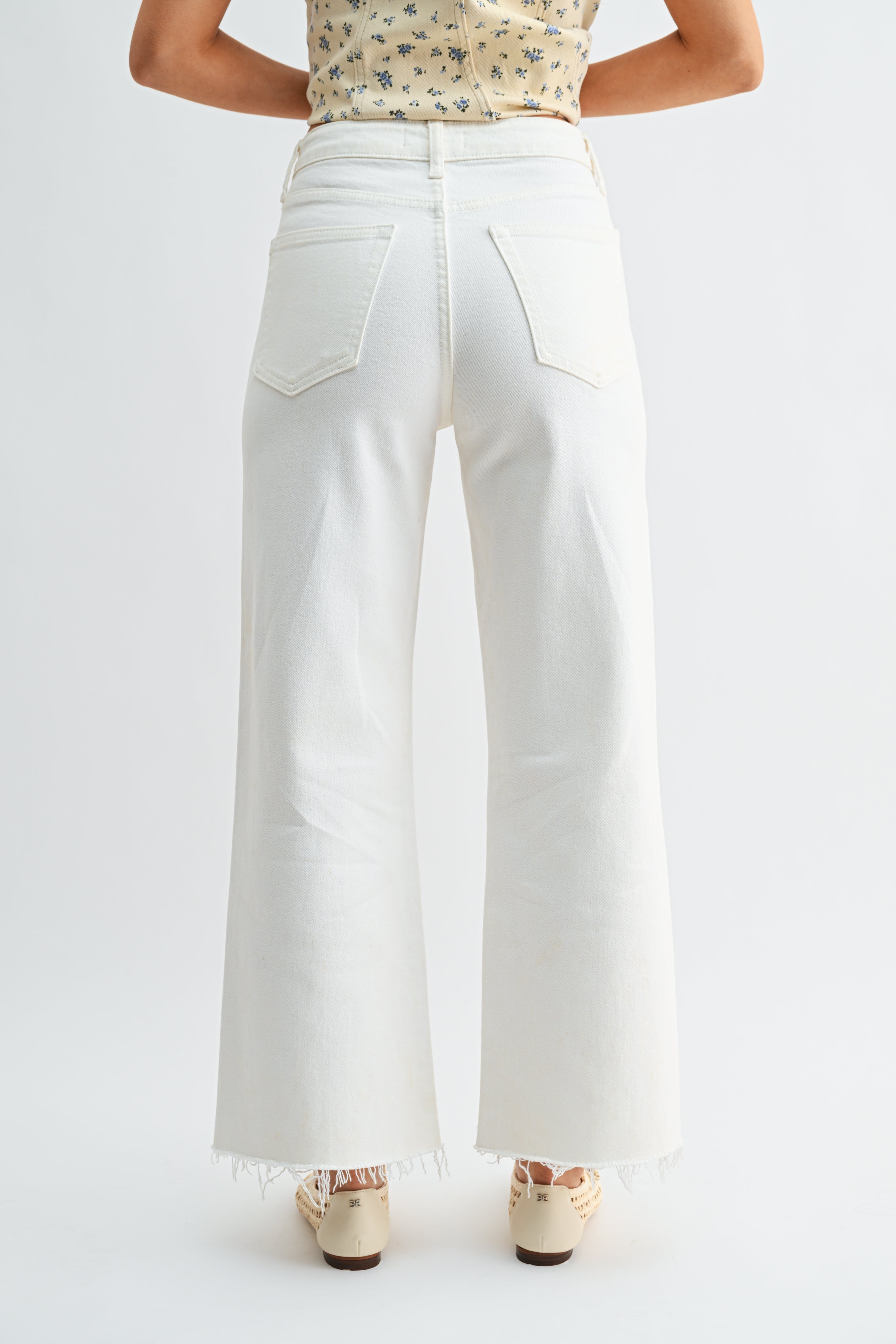 White wide-leg jeans worn by a person on a white background