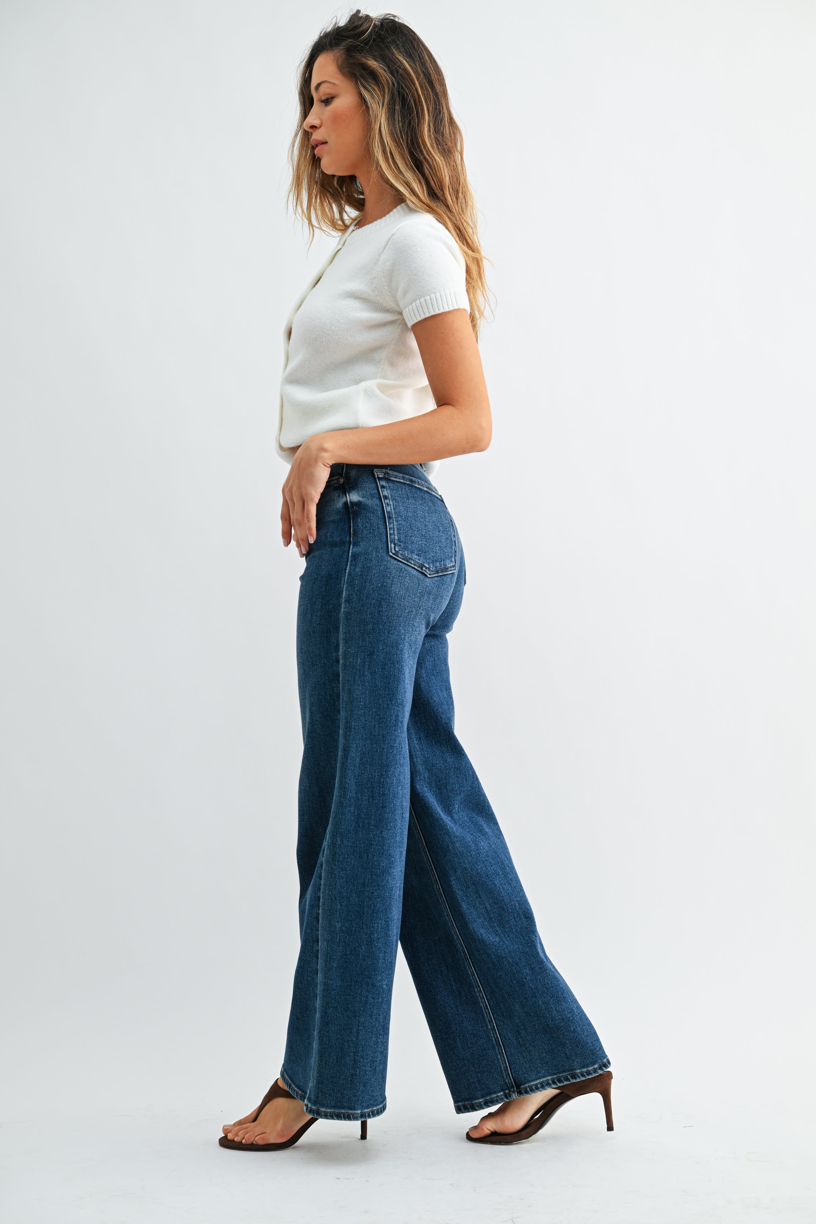 Woman wearing a white t-shirt and blue jeans on a white background