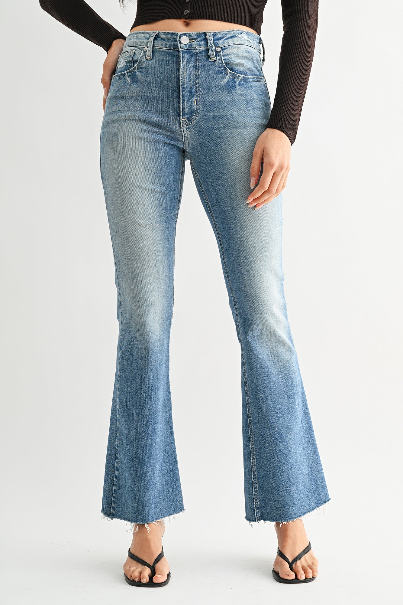 Flared jeans worn by a person on a white background