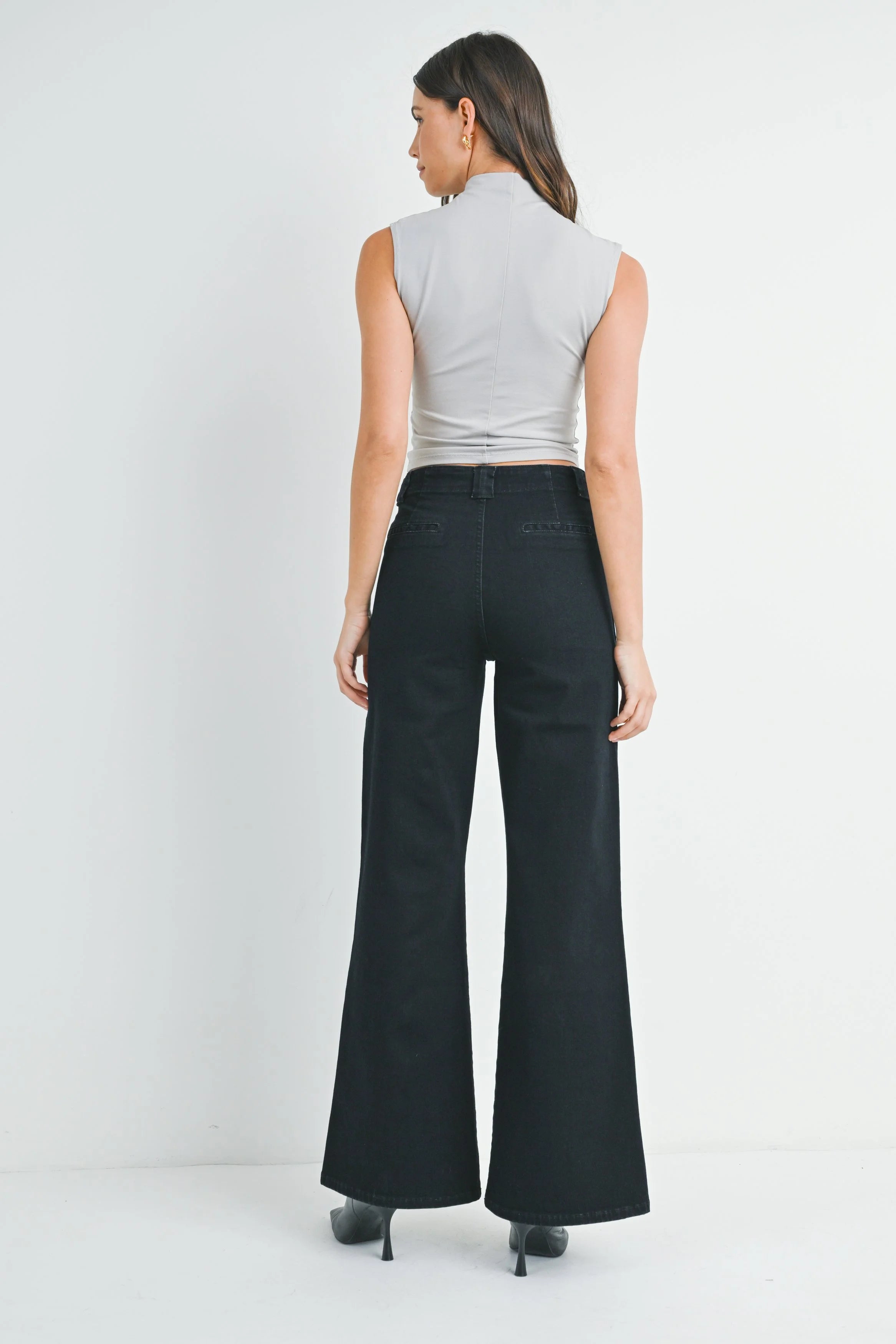 Woman modeling denim on a white background.