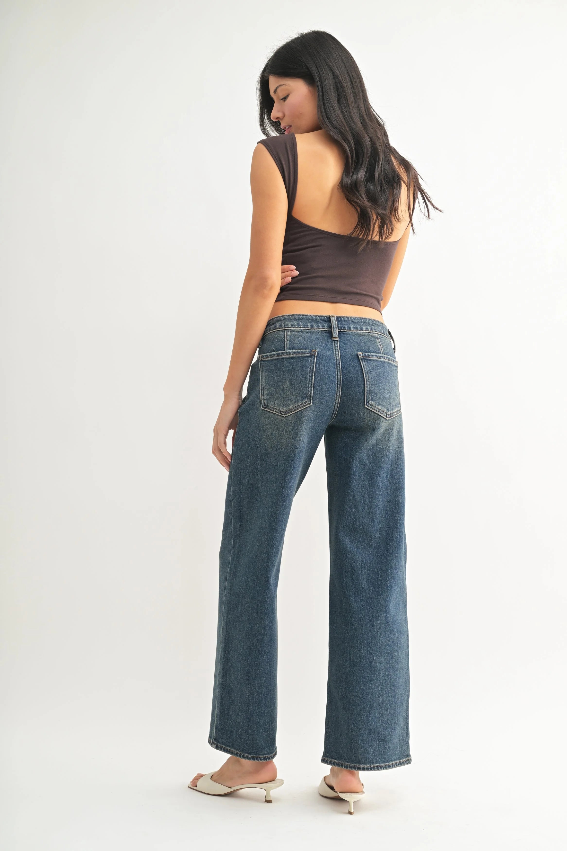 Woman modeling denim on a white background.