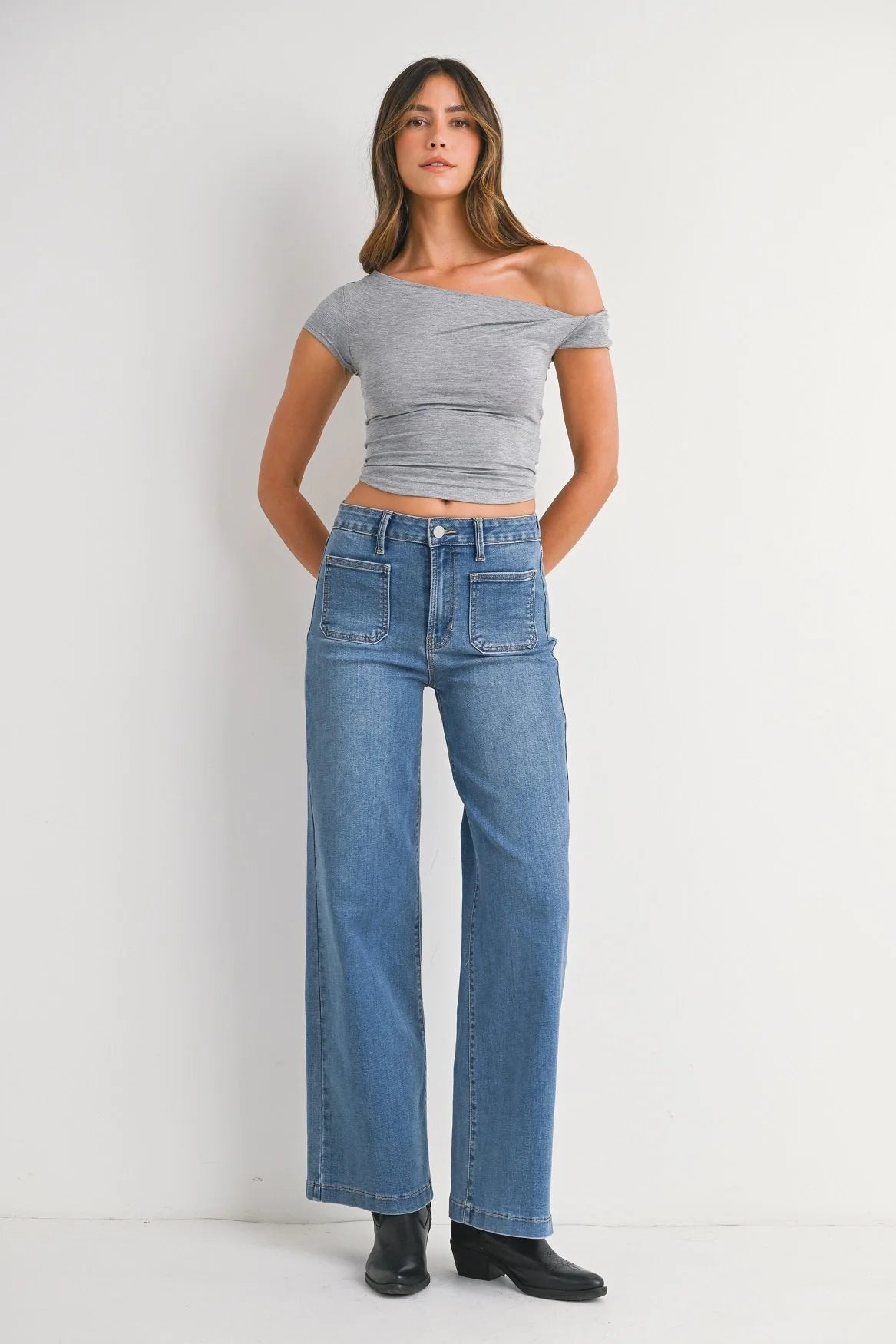 Woman modeling denim on a white background.