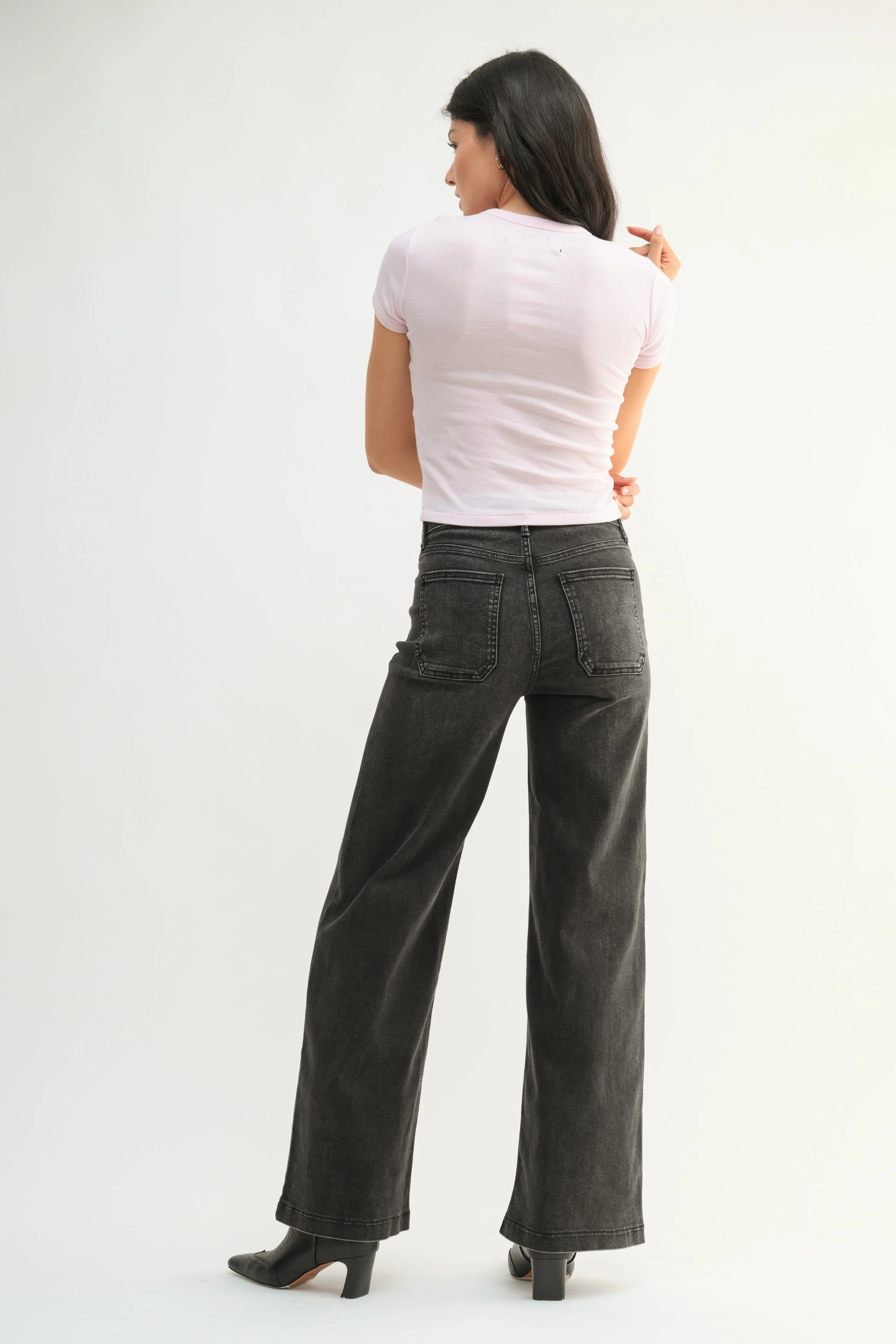 Woman modeling denim on a white background.