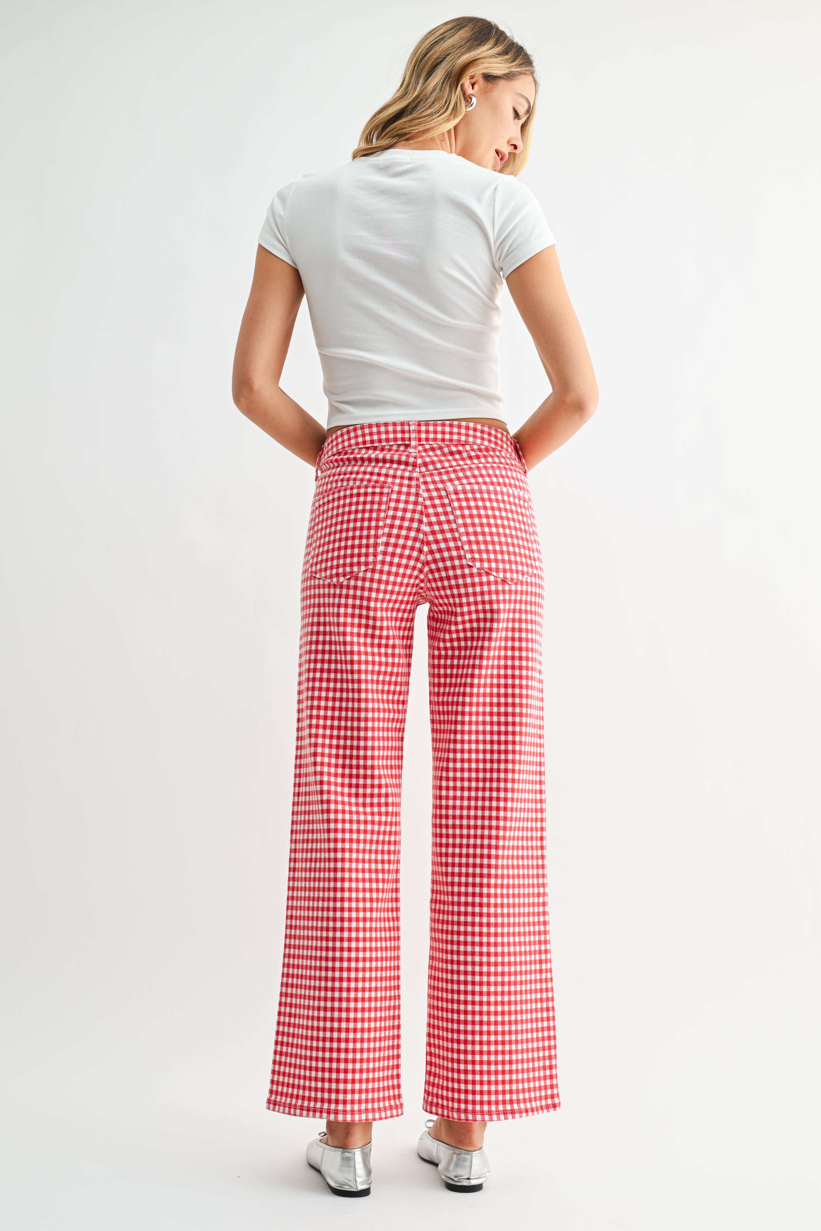 Woman wearing a white t-shirt and red checkered pants on a white background