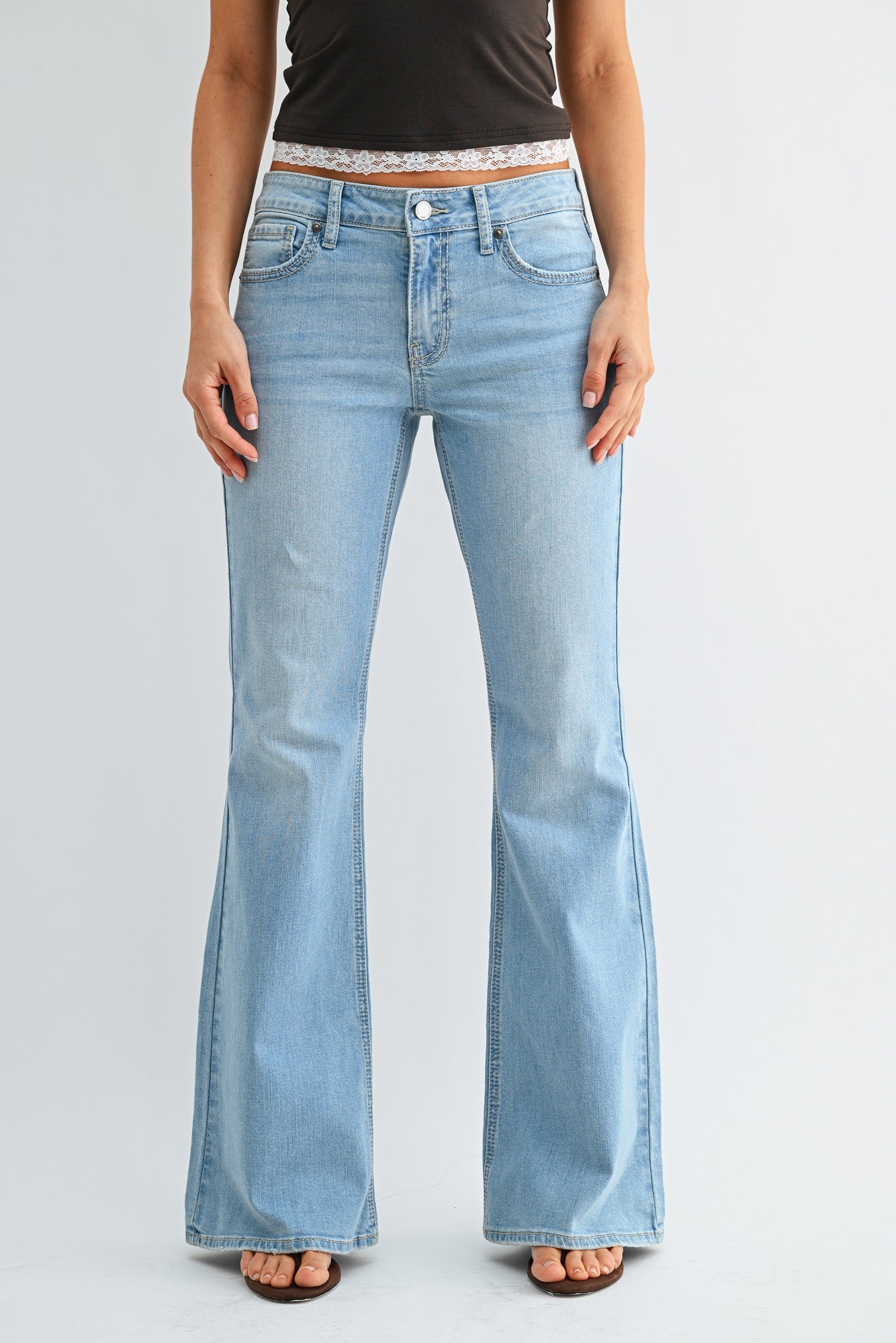 Light blue flared jeans worn by a person on a plain background