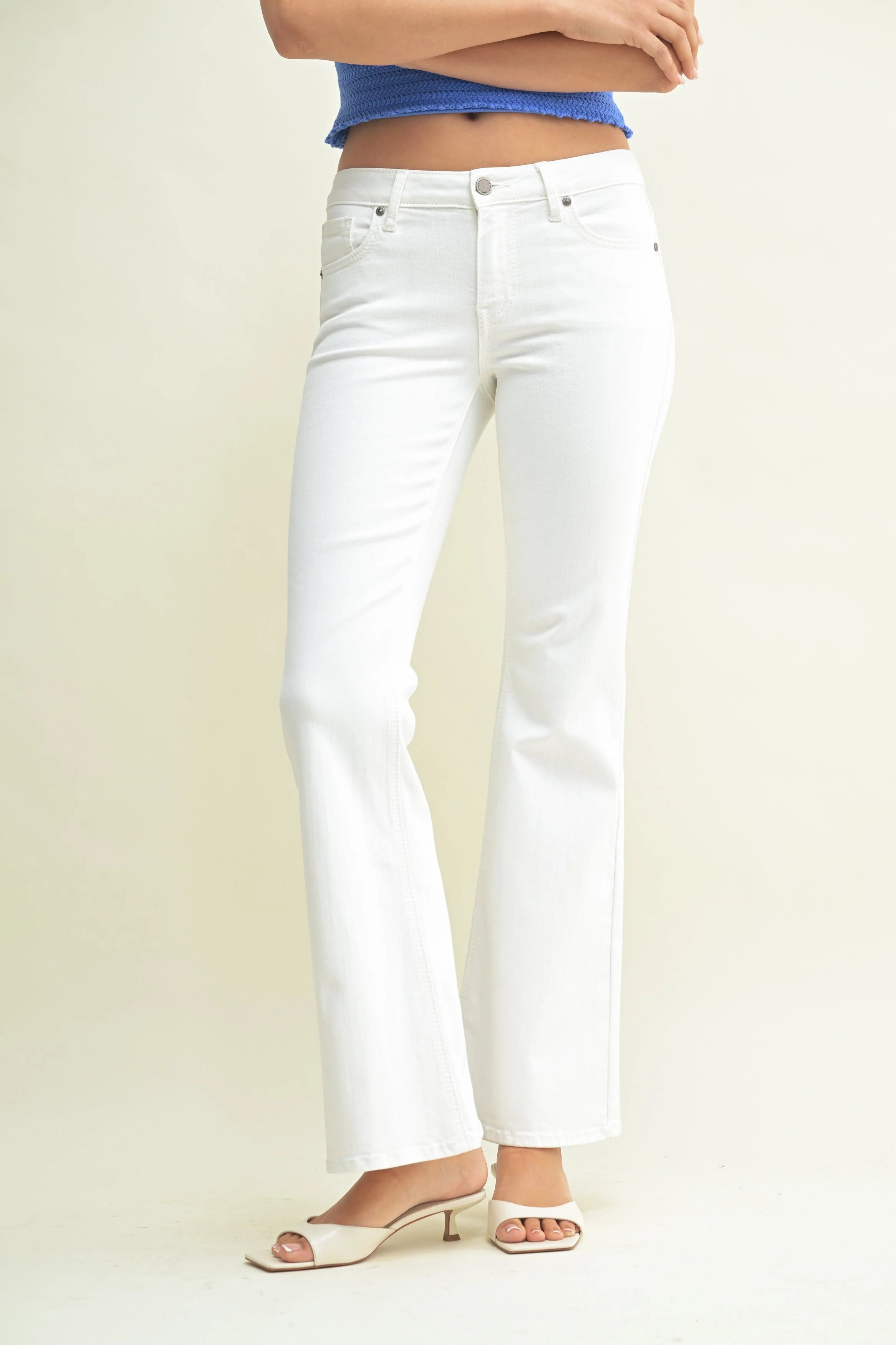 White jeans worn by a person on a plain background
