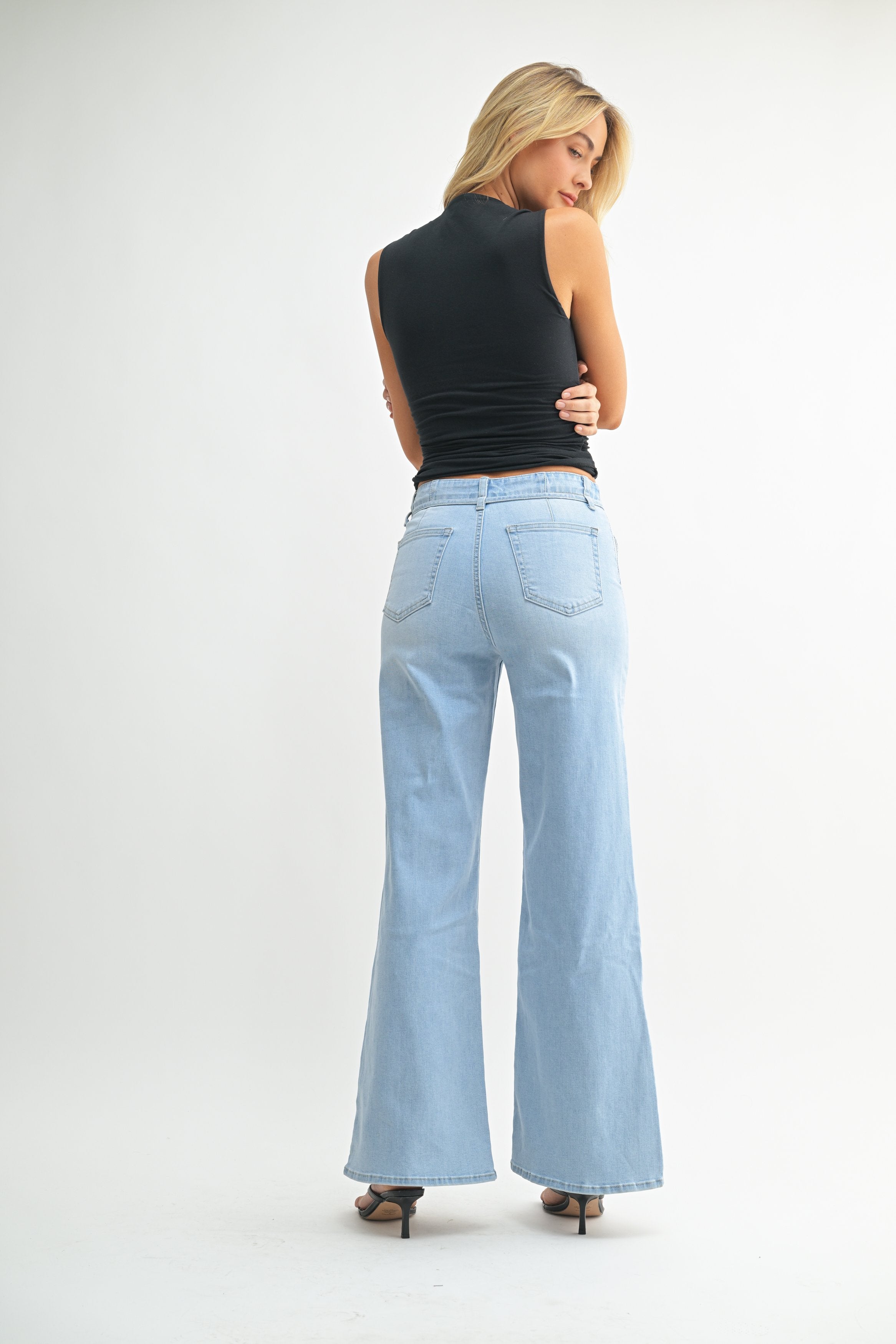 Woman modeling denim on a white background.
