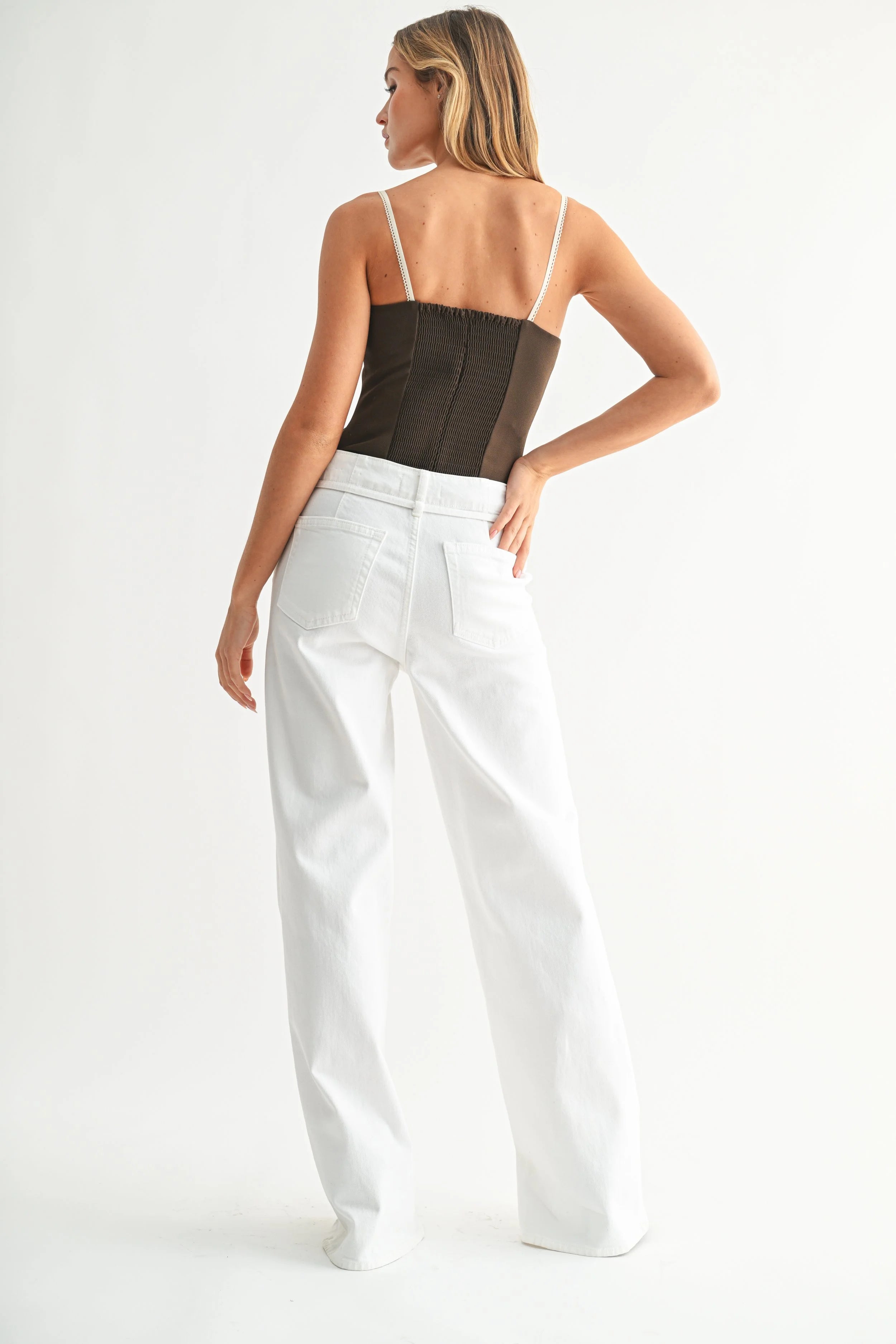 Woman modeling denim on a white background.