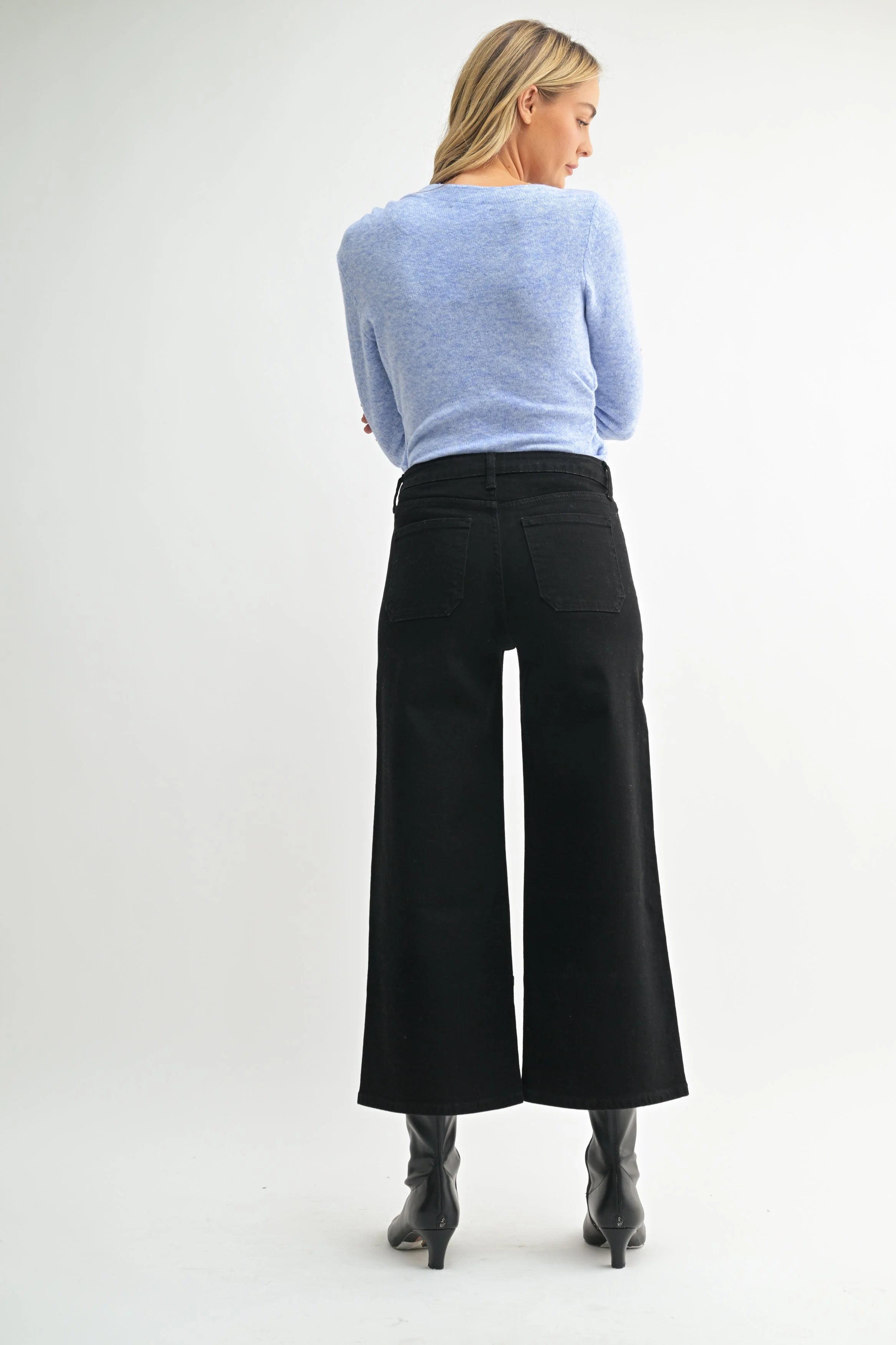 Woman modeling denim on a white background.