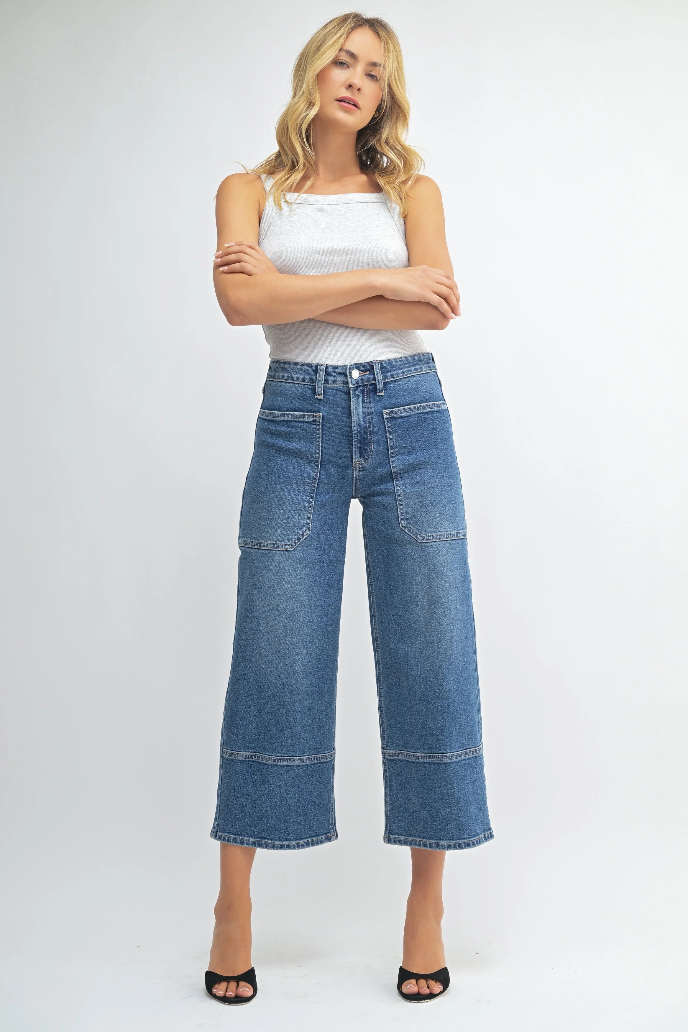 Woman wearing a white top and blue jeans on a white background