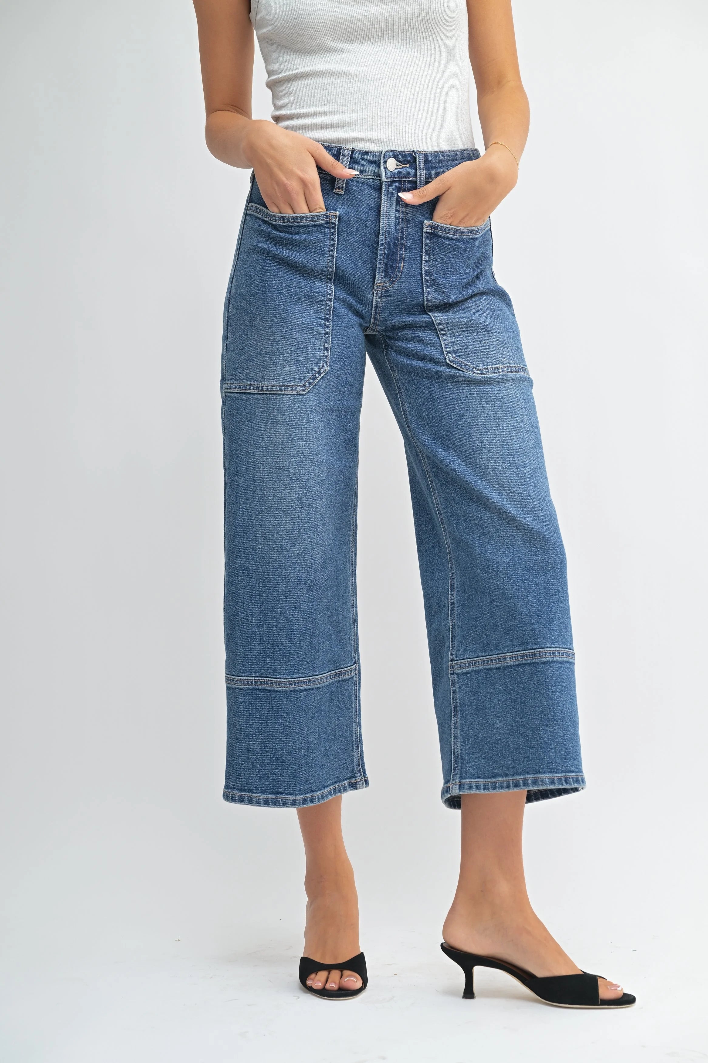 Woman modeling denim on a white background.