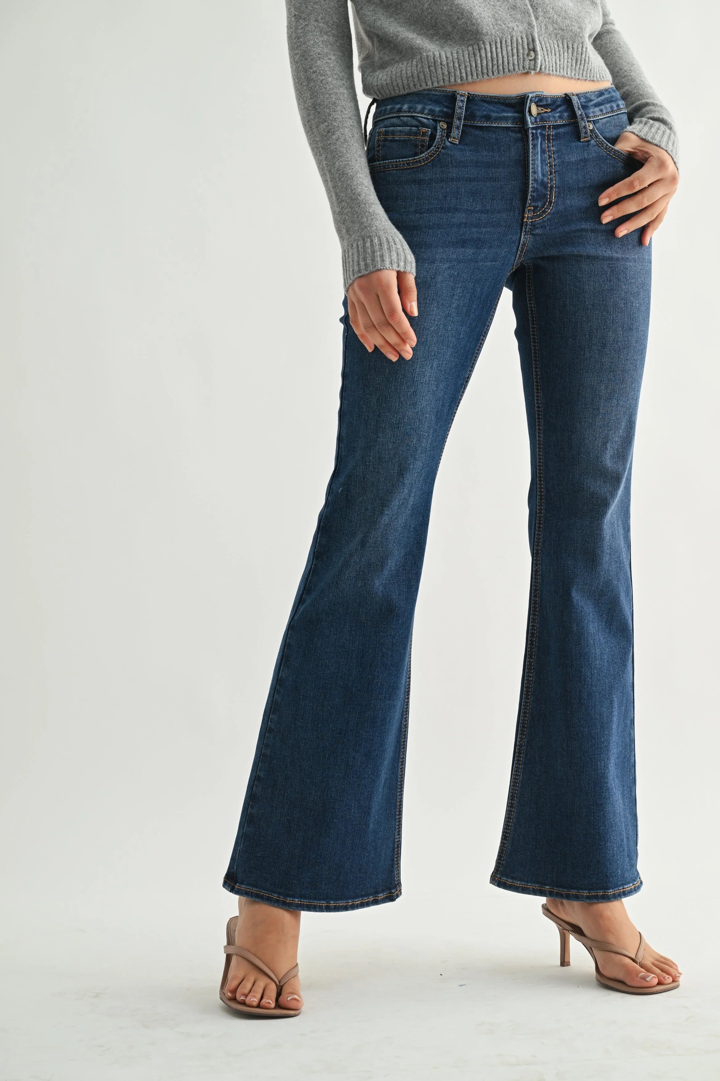 Person wearing blue flared jeans on a white background