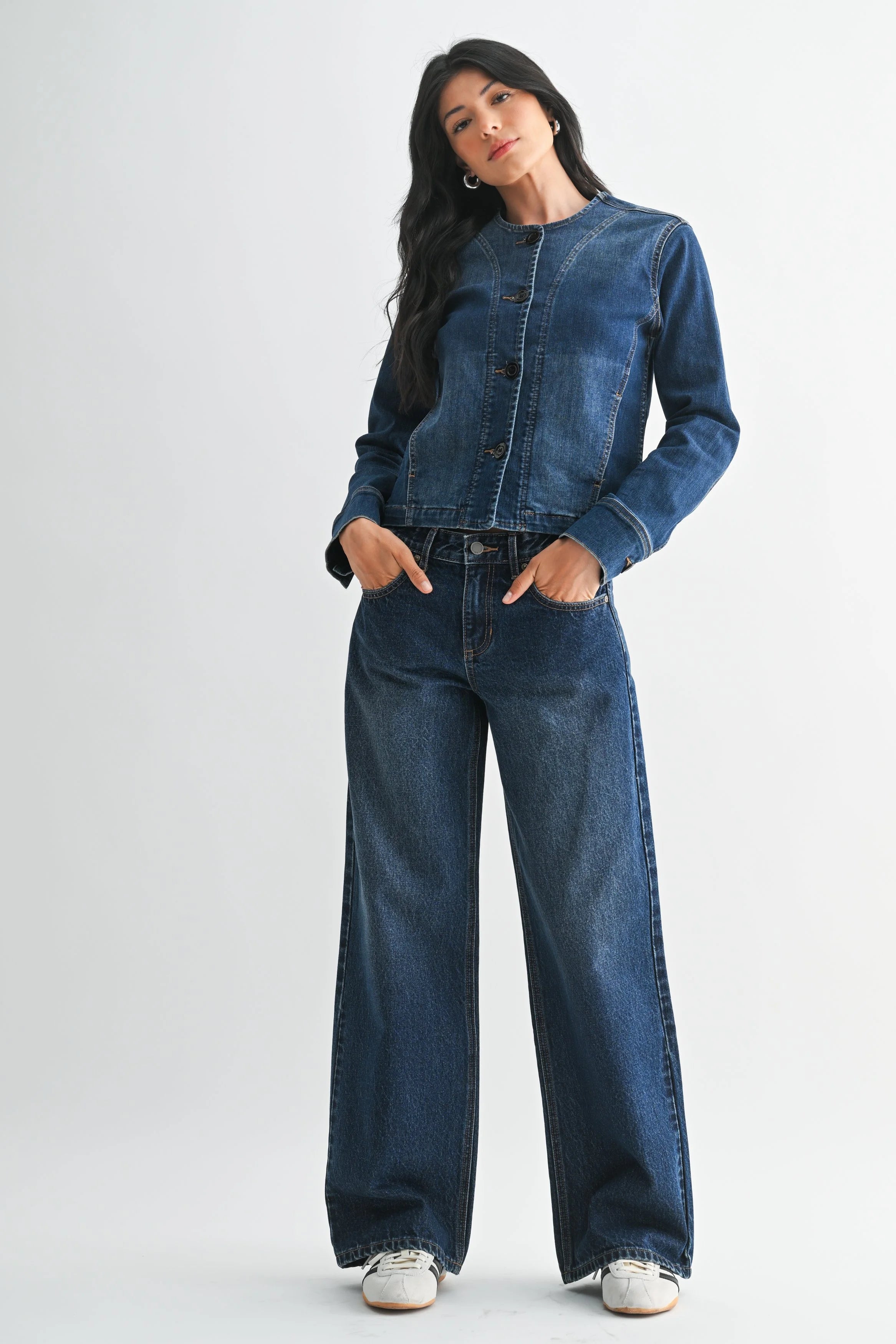 Woman modeling denim on a white background.