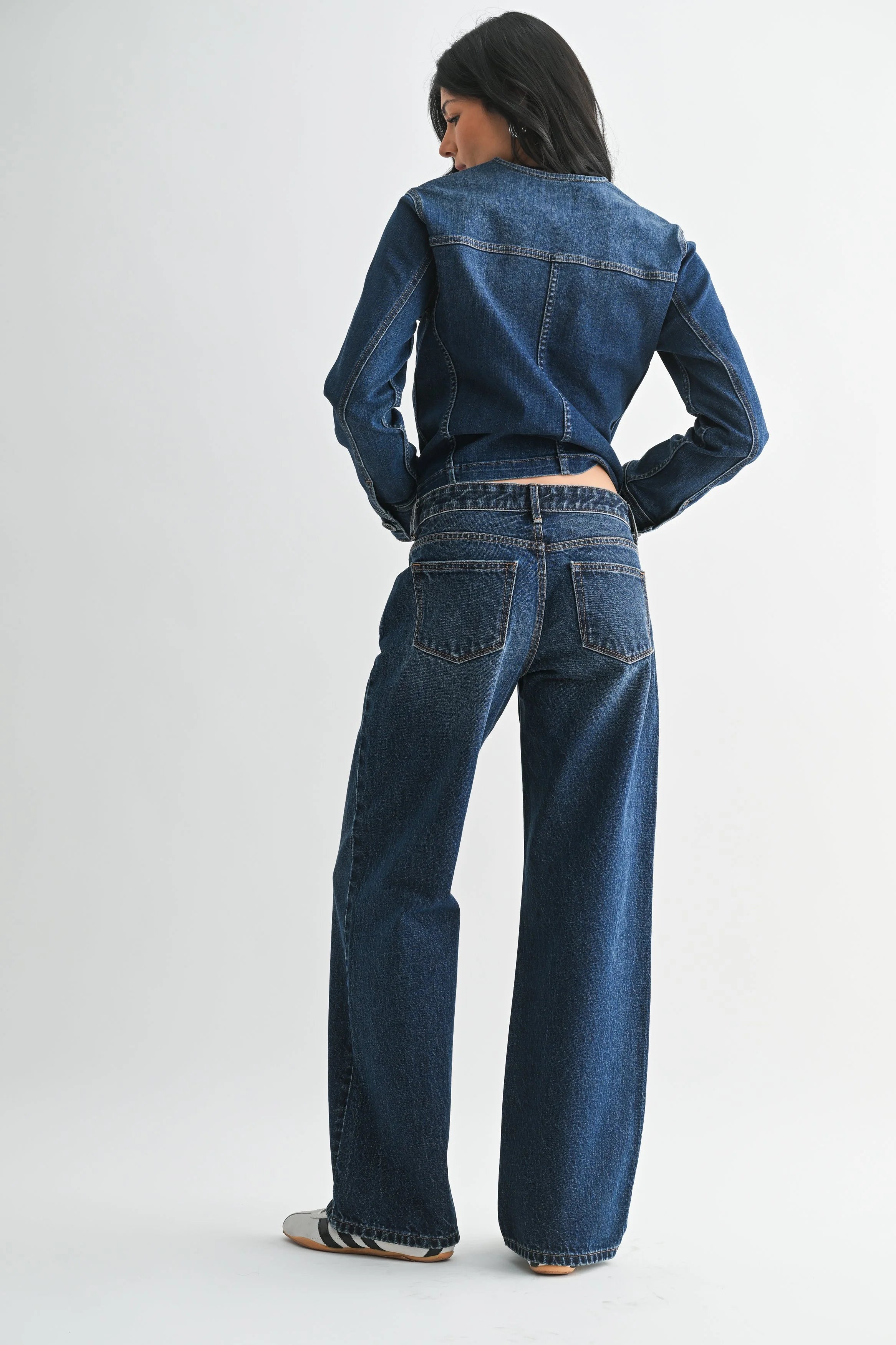 Woman modeling denim on a white background.