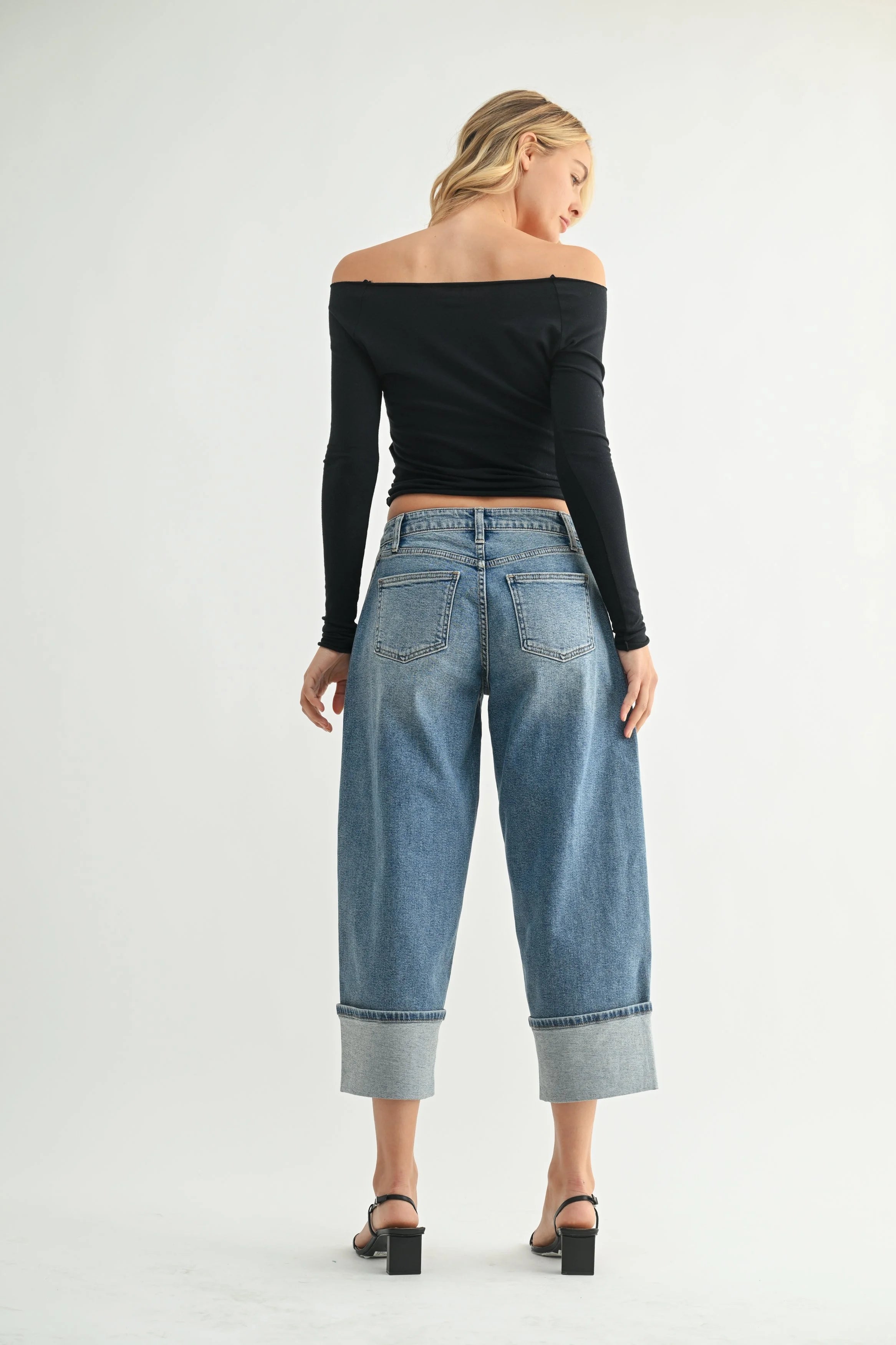 Woman modeling denim on a white background.