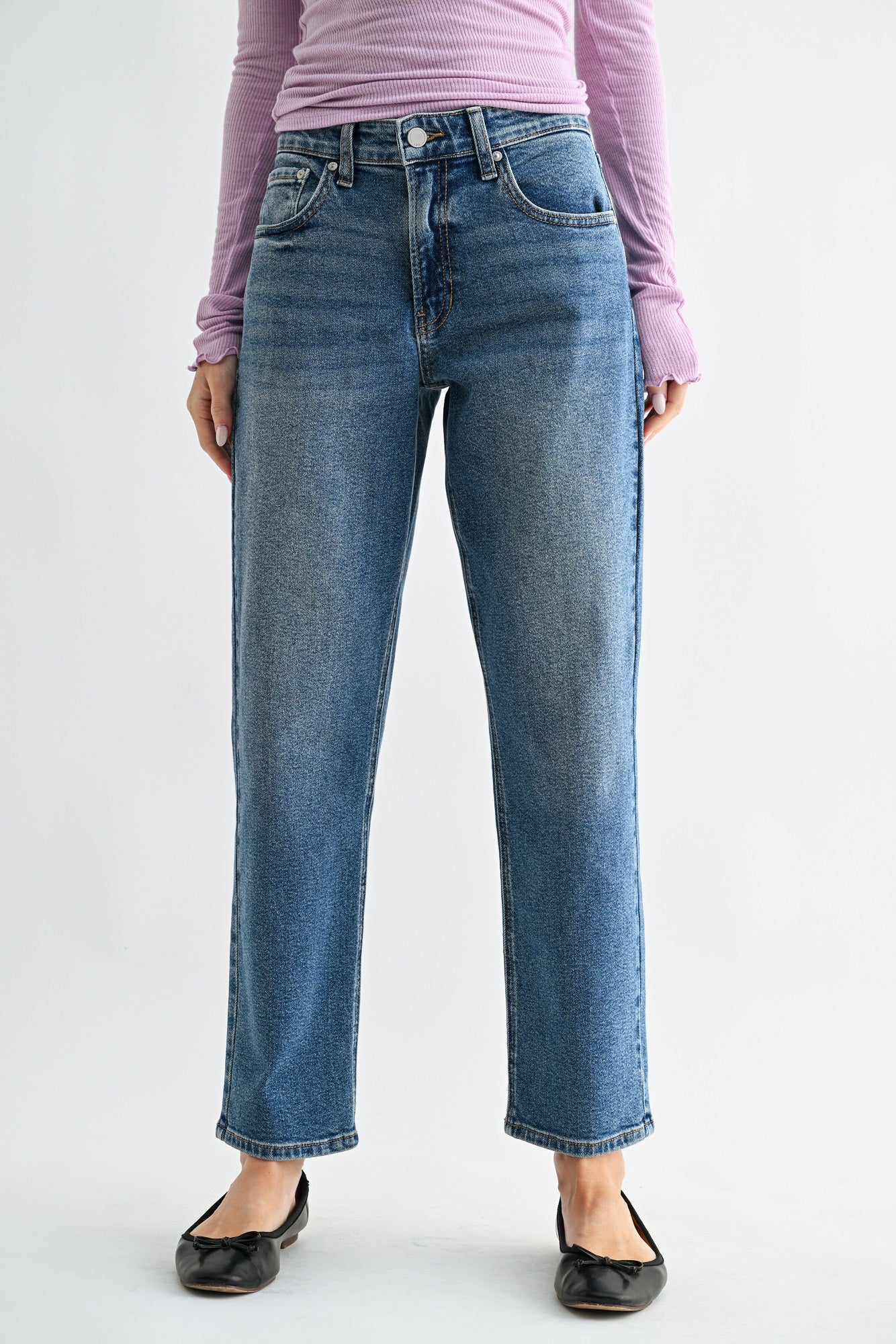 Person wearing blue jeans and a pink top on a white background