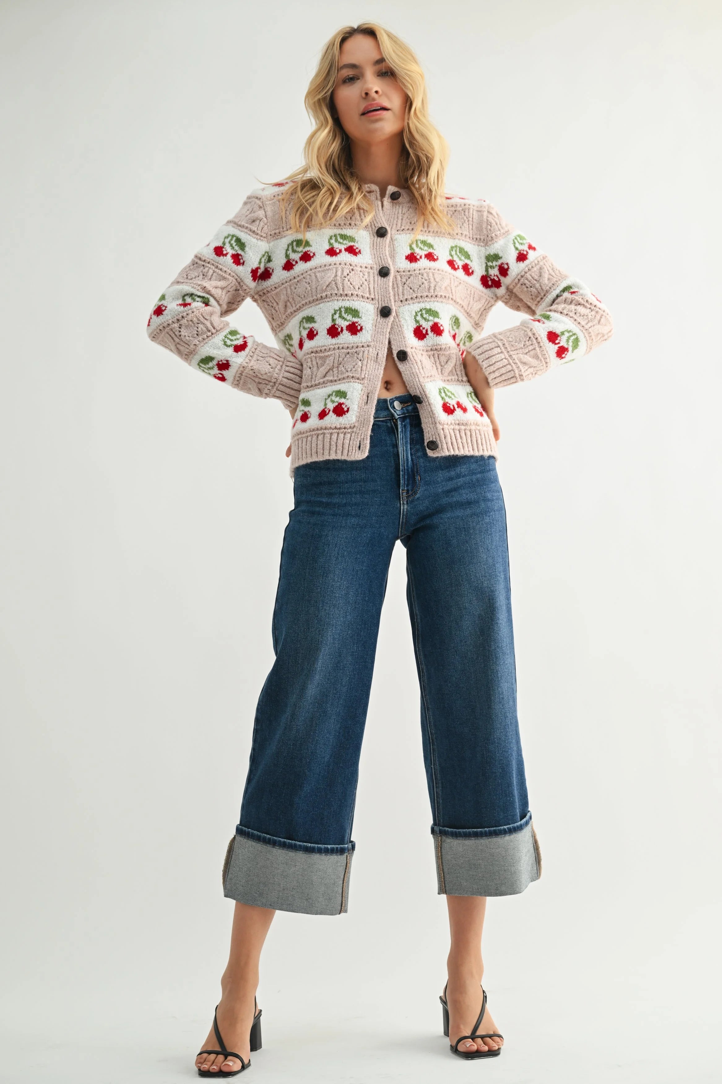 Woman wearing a patterned sweater and jeans on a white background