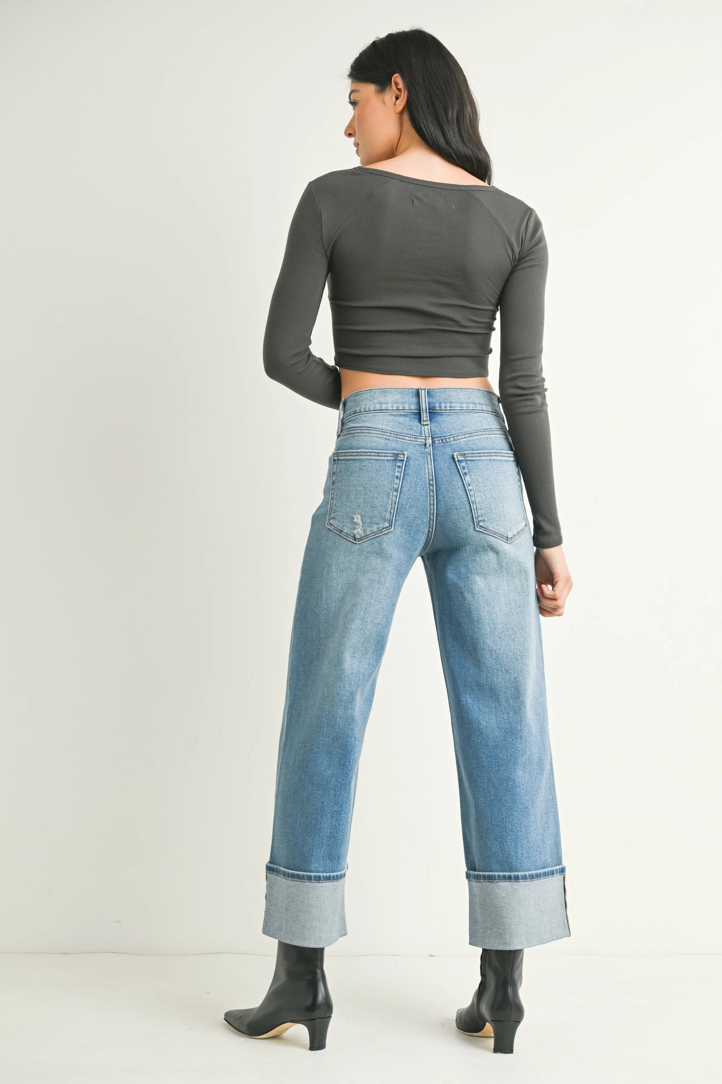 Woman modeling denim on a white background.