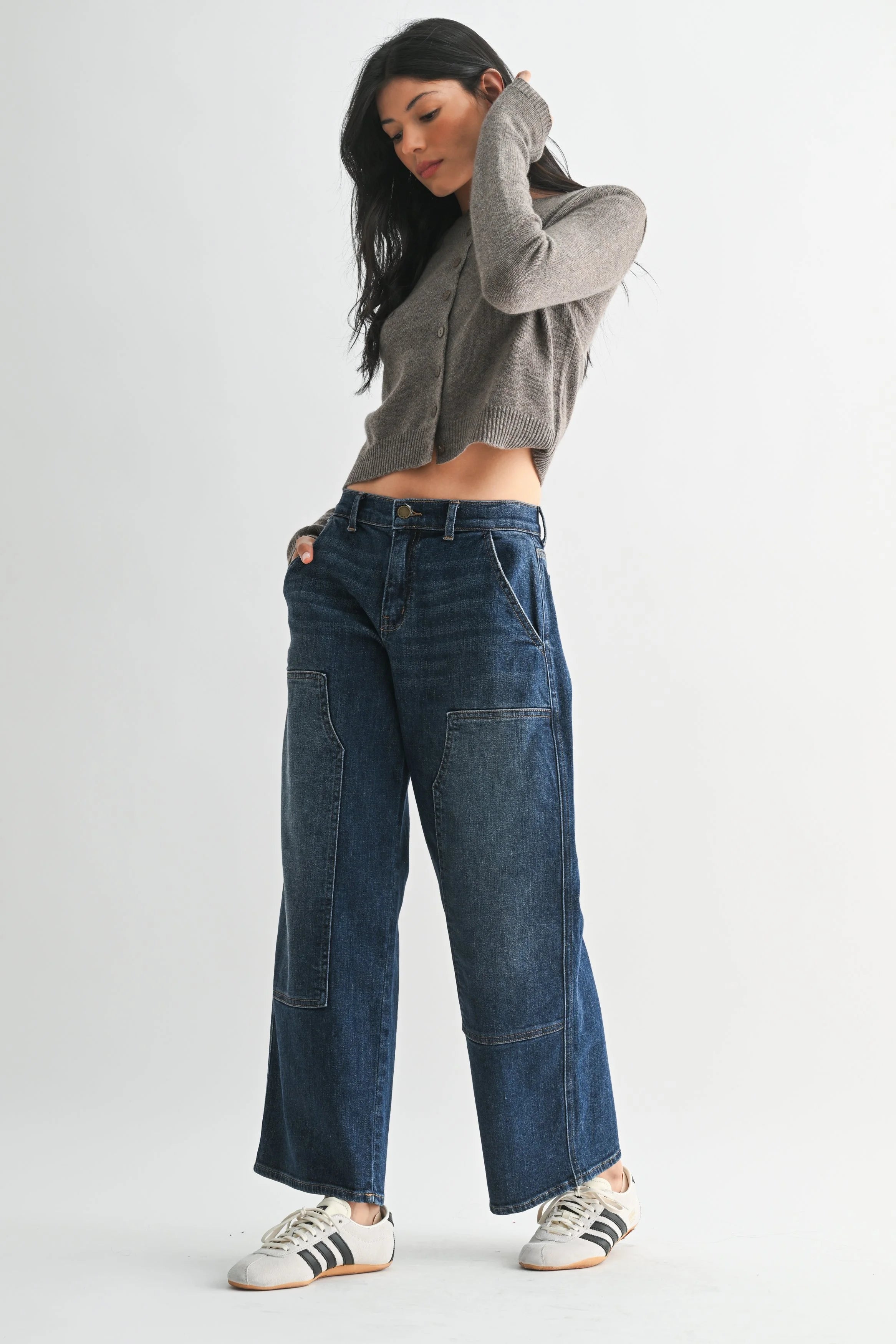 Woman modeling JBD denim on a white background.