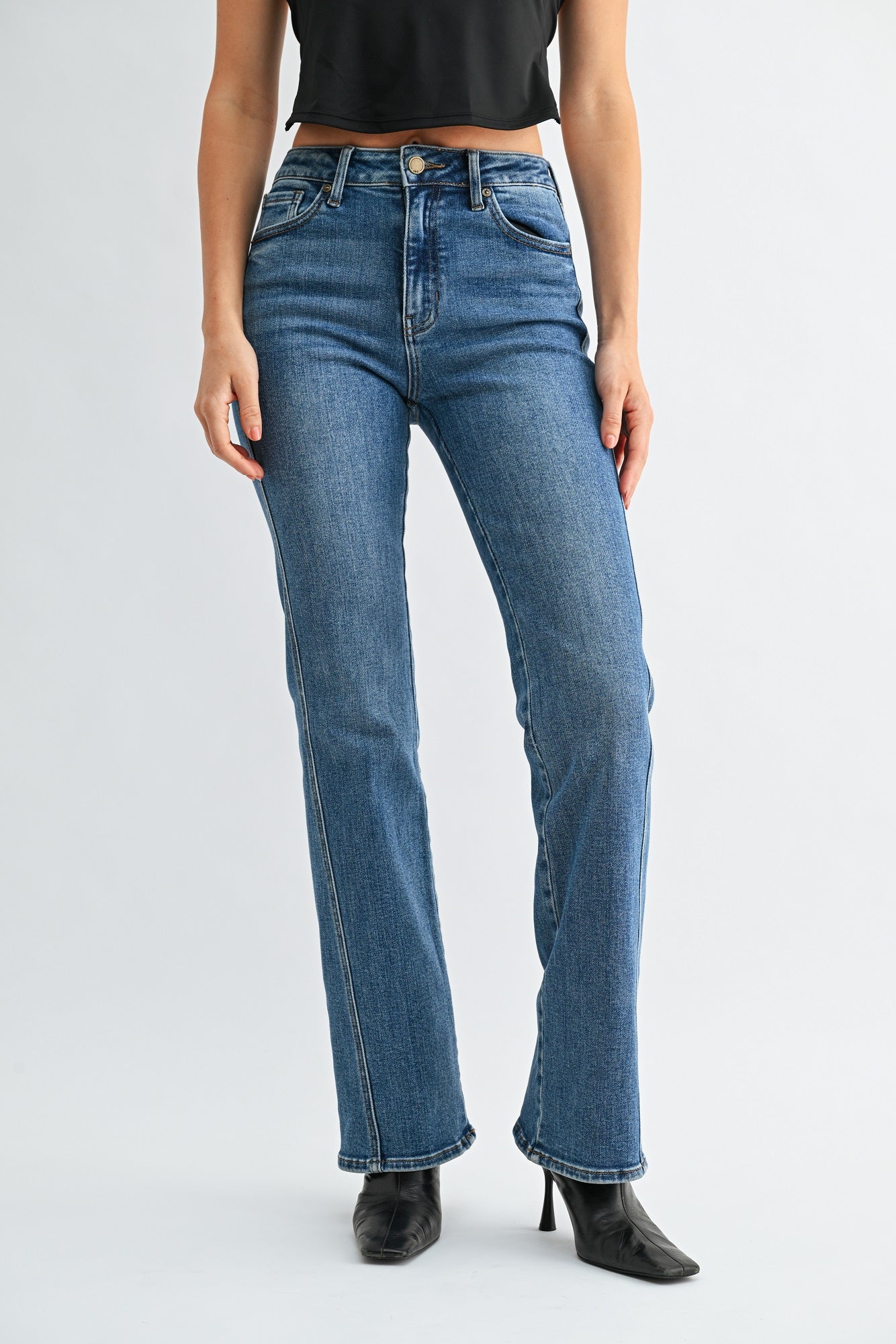 Person wearing blue jeans on a plain background