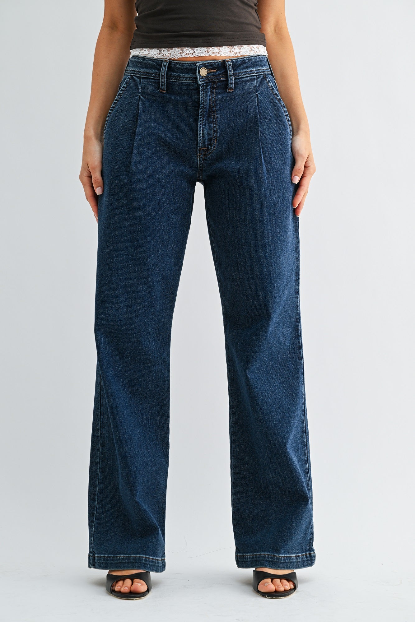 Person wearing blue jeans on a plain background