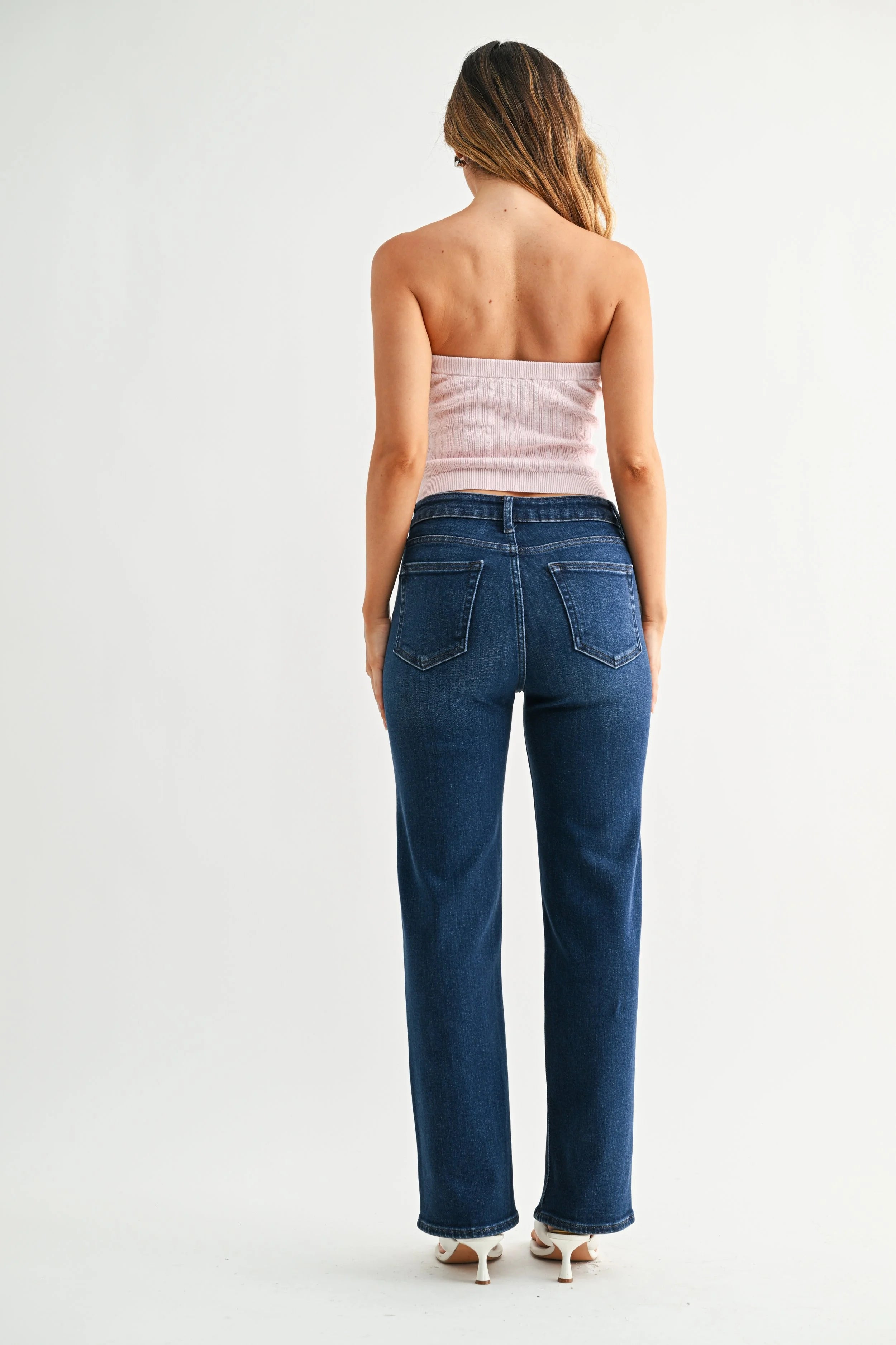 Woman modeling JBD denim on a white background.