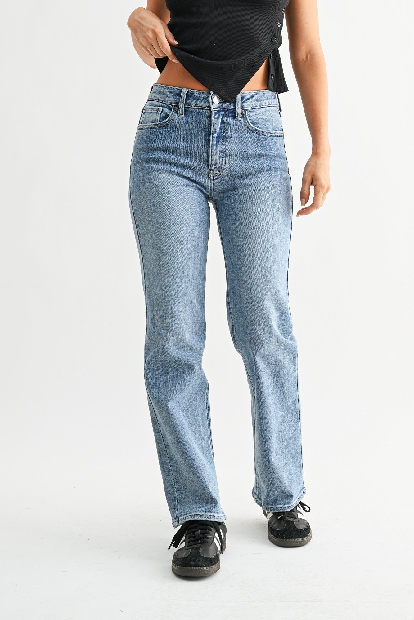 Person wearing light blue jeans on a white background