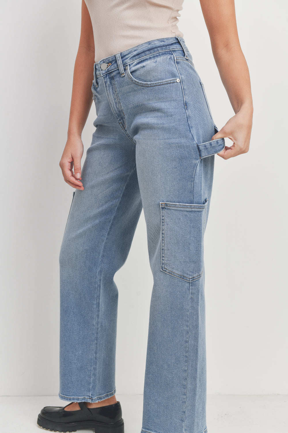 Person wearing light blue jeans on a plain background